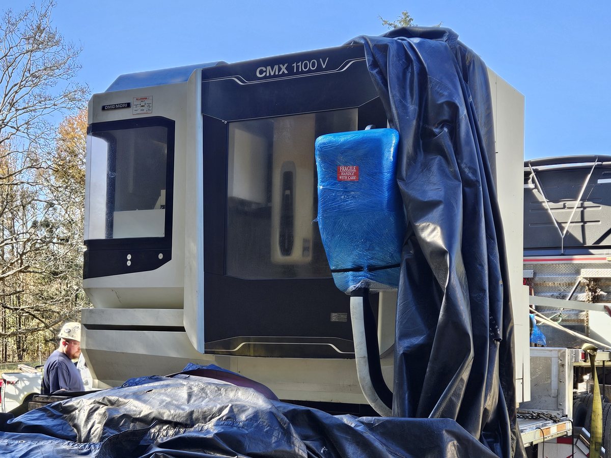 Our DMG MORI CMX 1100 V coming off the truck, still half wrapped in tarps