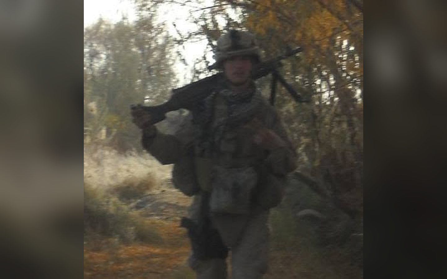 A machine gunner walking out of the trees
