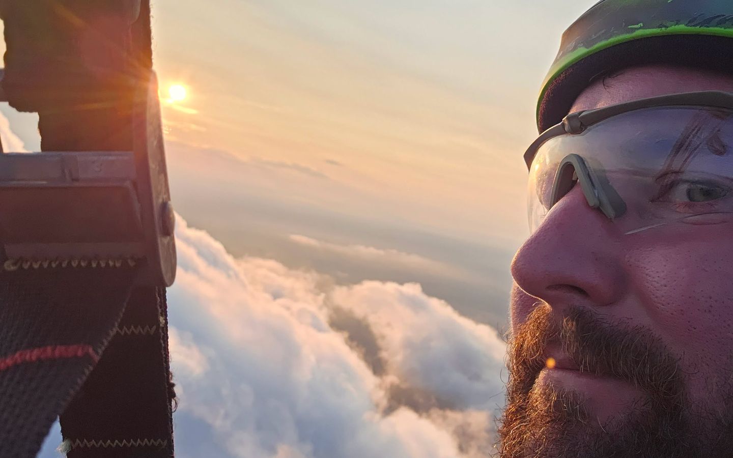 Daniel in helmet and glasses above the clouds