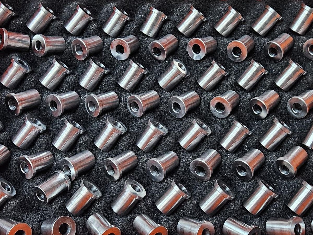 A lot of turned steel bushings in a foam-lined case