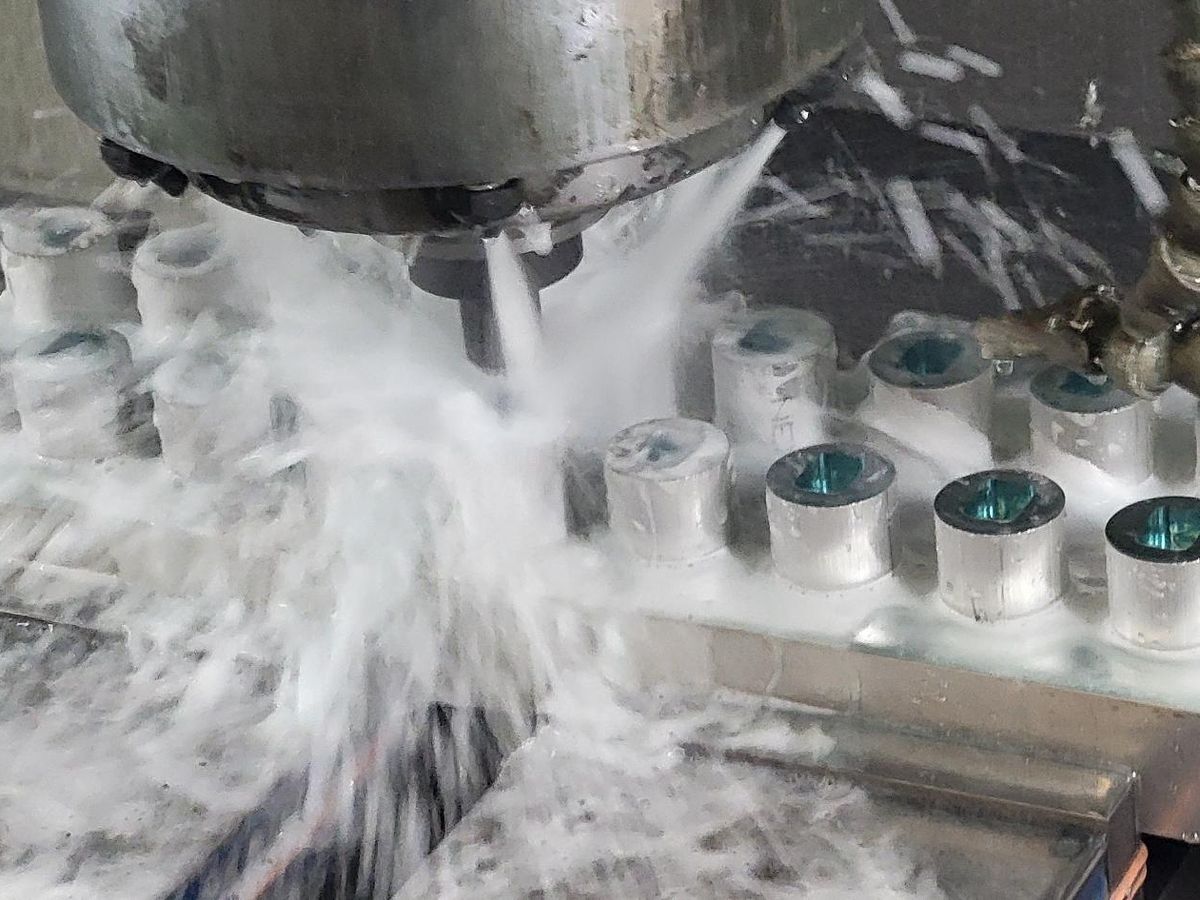 Parts being milled on a vise-mounted pallet under coolant